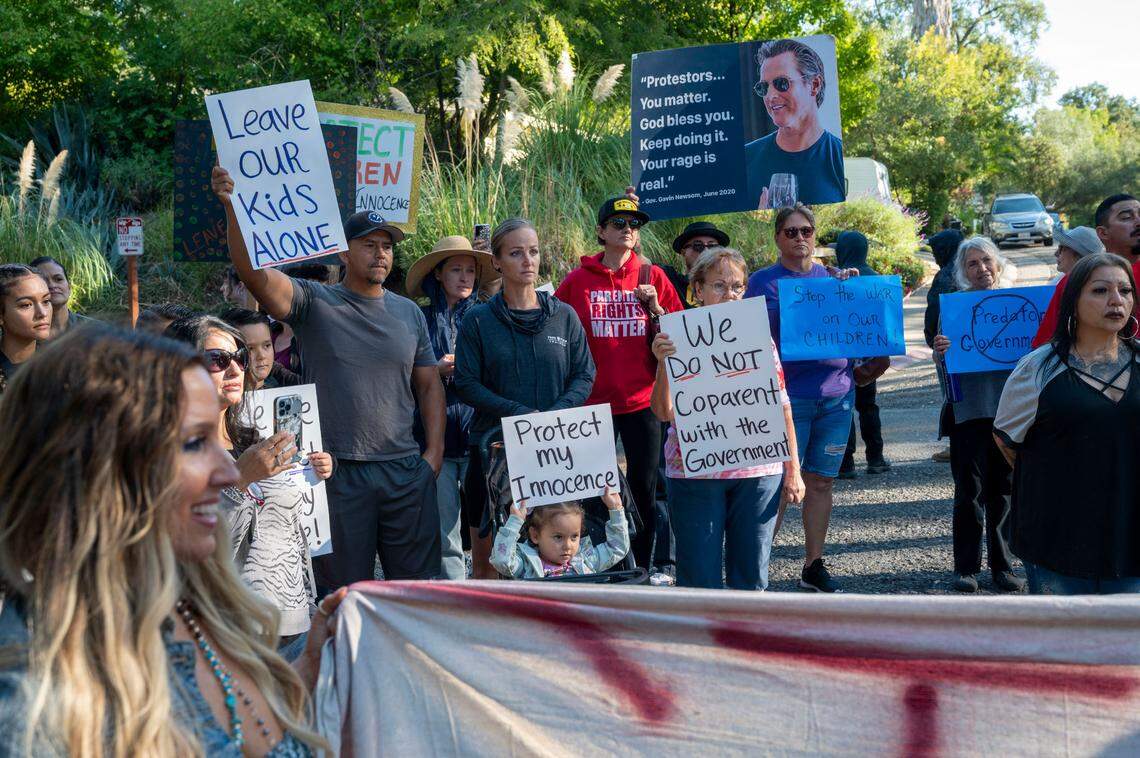 Tara Thornton, left, co-founder of Freedom Angels, stands with parents’ rights activists who rallied outside Gov. Newsom’s home to protest trans bills and what they call the “War on Children” on Saturday in Fair Oaks.