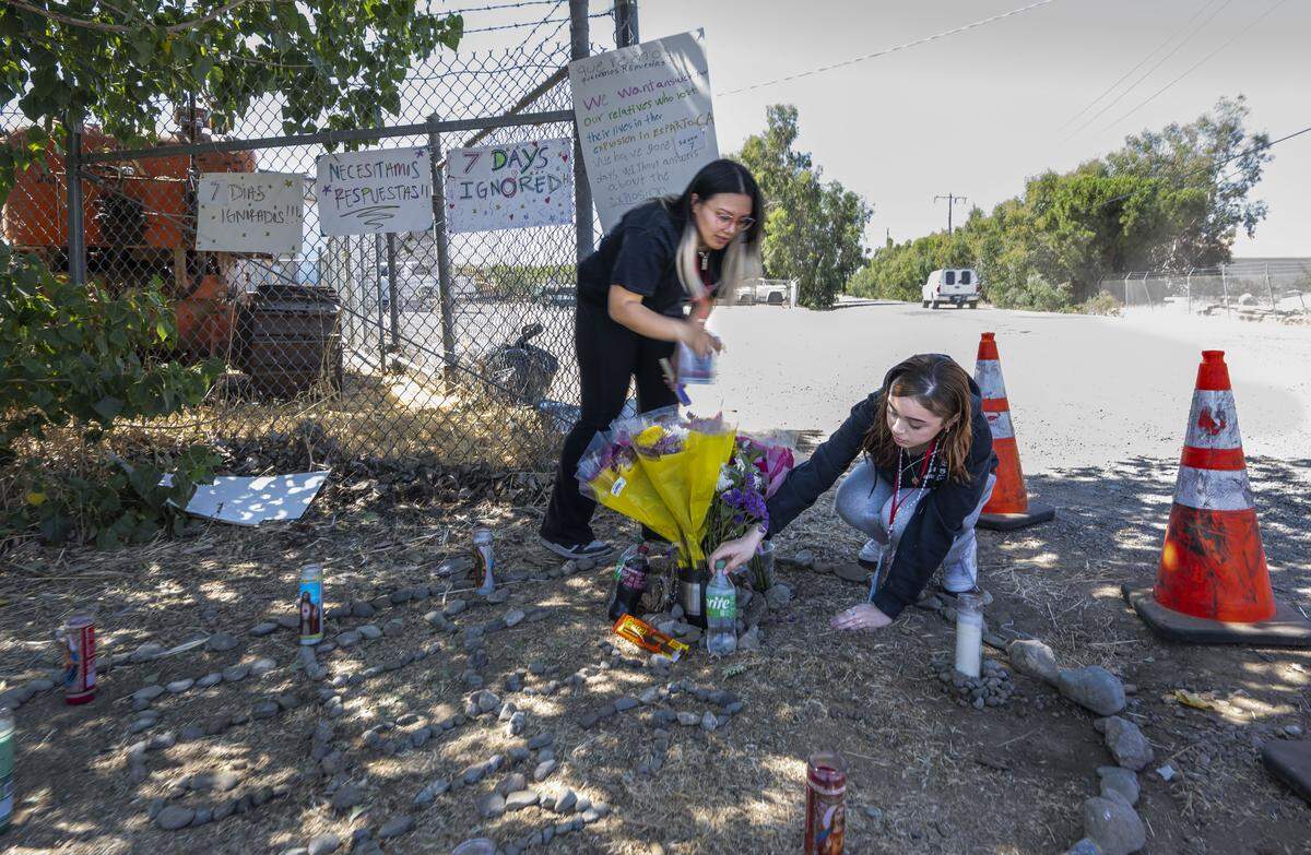 Charlize Hernandez, of Fremont, who lost three cousins in the Esparto pyrotechnics compound fire and Syanna Ruiz, of San Leandro, who lost her boyfriend Jesus Ramos, place food and drinks that the young men liked at an alter after were family members gathered on July 7.