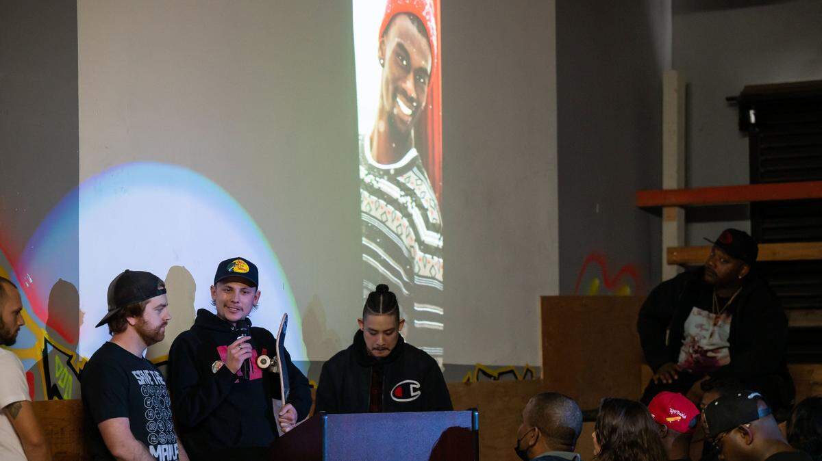 Austin Roberts holds his skateboard and recalls good memories during a memorial and celebration of life for Sacramento native Tyre Nichols at Sac Ramp Skate Shop on Saturday while surrounded by other friends, from left, Nick Dragonetti, Ryan Wilson and Harry Silva. A photo of Nichols, who was beaten by Memphis police and died Jan. 10, is projected behind them. Family members also spoke, including Nichols’ brother, Jamal Dupree, at right.