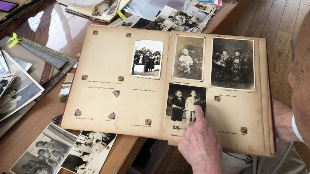 George Uno looks through archives at home in Japan. The five-hour documentary series “Asian Americans” is airing on PBS through June 8.