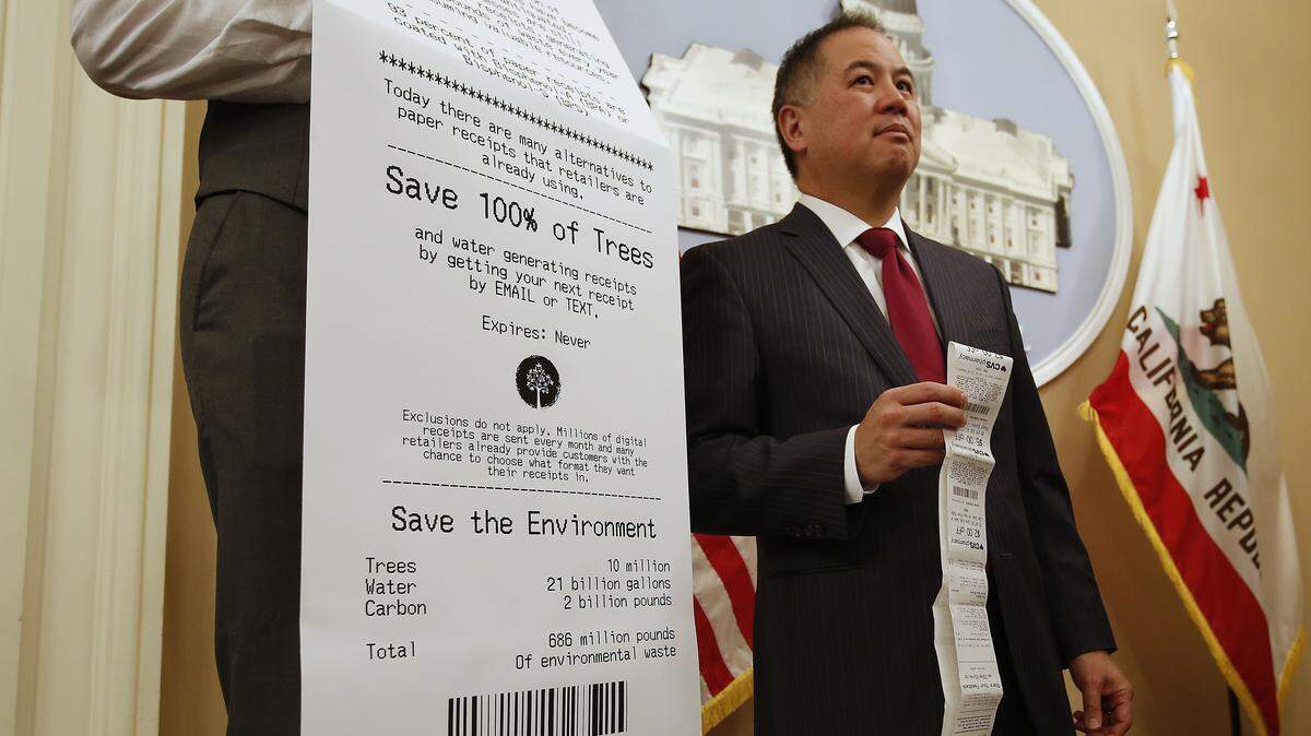 Assemblyman Phil Ting, D-San Francisco, displays a long paper receipt as he discusses his bill to require businesses to offer electronic receipts, Tuesday, Jan. 8, 2019, in Sacramento, Calif. Under the legislation customers could receive a paper receipt on request. (AP Photo/Rich Pedroncelli)
