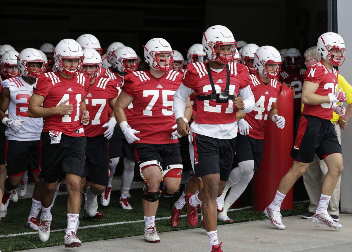 Wearing a camera around his neck, Nebraska defensive back Lamar Jackson leads teammates onto the practice field in Lincoln, Neb., in July 2017.
