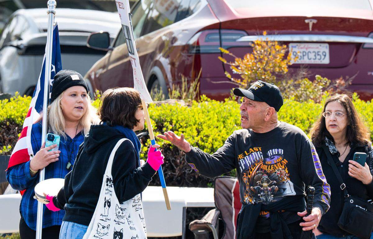 A Trump supporter argues with anti-Tesla demonstrator Christina Rosen in front of the Tesla dealership in Rocklin on Saturday, March 29, 2025.