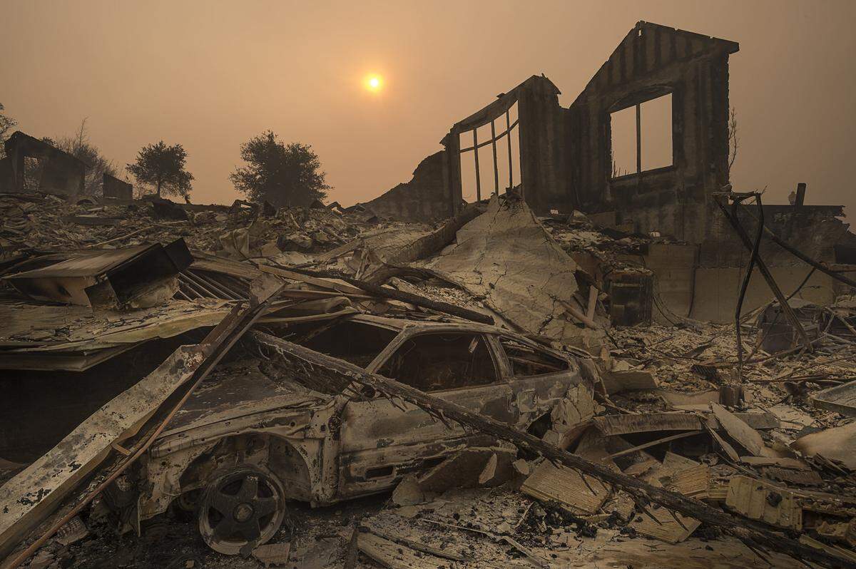 The sun rises through a cloud of smoke in the Rincon Ridge area after a wildfire in Sonoma County on Tuesday October 10, 2017 in Santa Rosa, Calif.