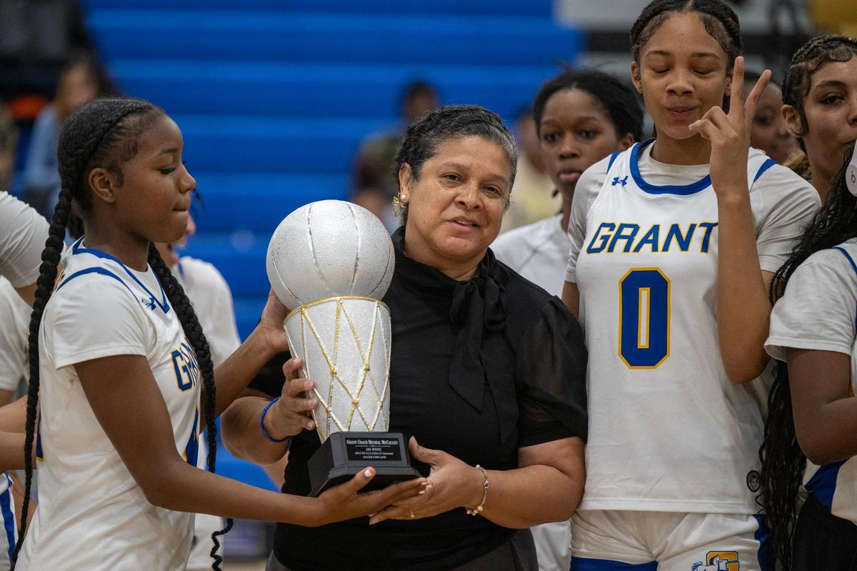 Grant Pacers coach Michelle McCauley, flanked by players Nerissa Hamilton (4) and Asia Washington (0), is recognized for 200 career wins before a game against the Kennedy Cougars on Friday.
