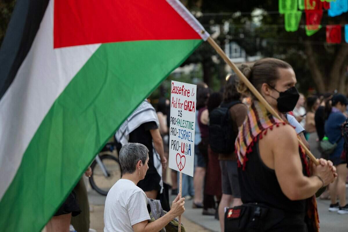 Lisa Baumeister of Davis holds a sign calling for a ceasefire and aid for Gaza during a candlelight vigil by the Sacramento Regional Coalition for Palestinian Rights opposing the conflict in Gaza on Monday in Sacramento. About 200 supporters held a rally in Caesar Chavez Park and then walked to a Palestine national flag mural and to place candles.