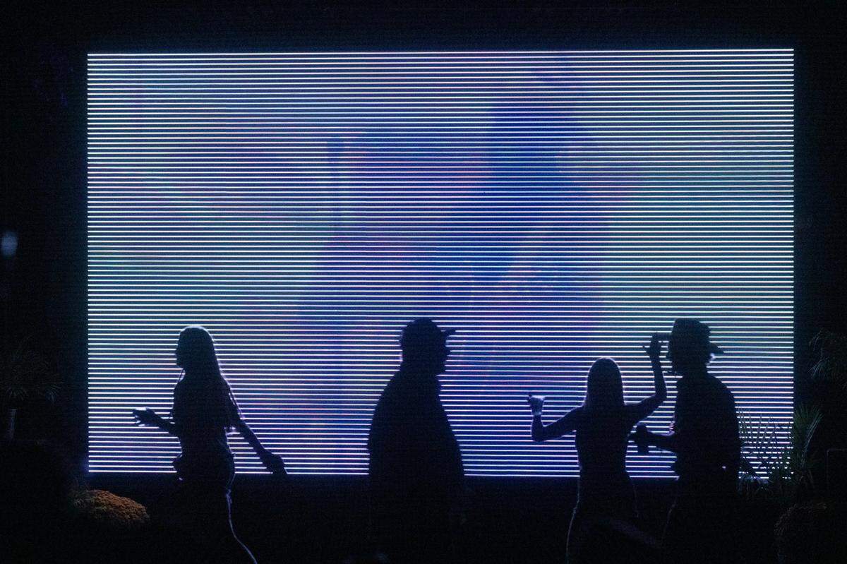 Fans walk past TV monitors during the GoldenSky Country Music Festival at Discovery Park in Sacramento on Friday, Oct. 18, 2024.