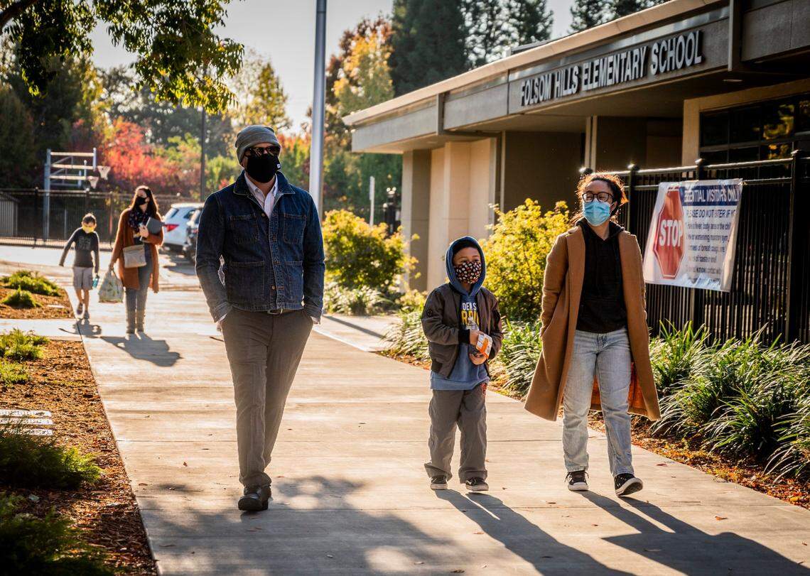 Florencio Sinogui, left, and Tyara Sinogui, right, walk their son Layden to school at Folsom Hills Elementary on Thursday, Nov. 12.