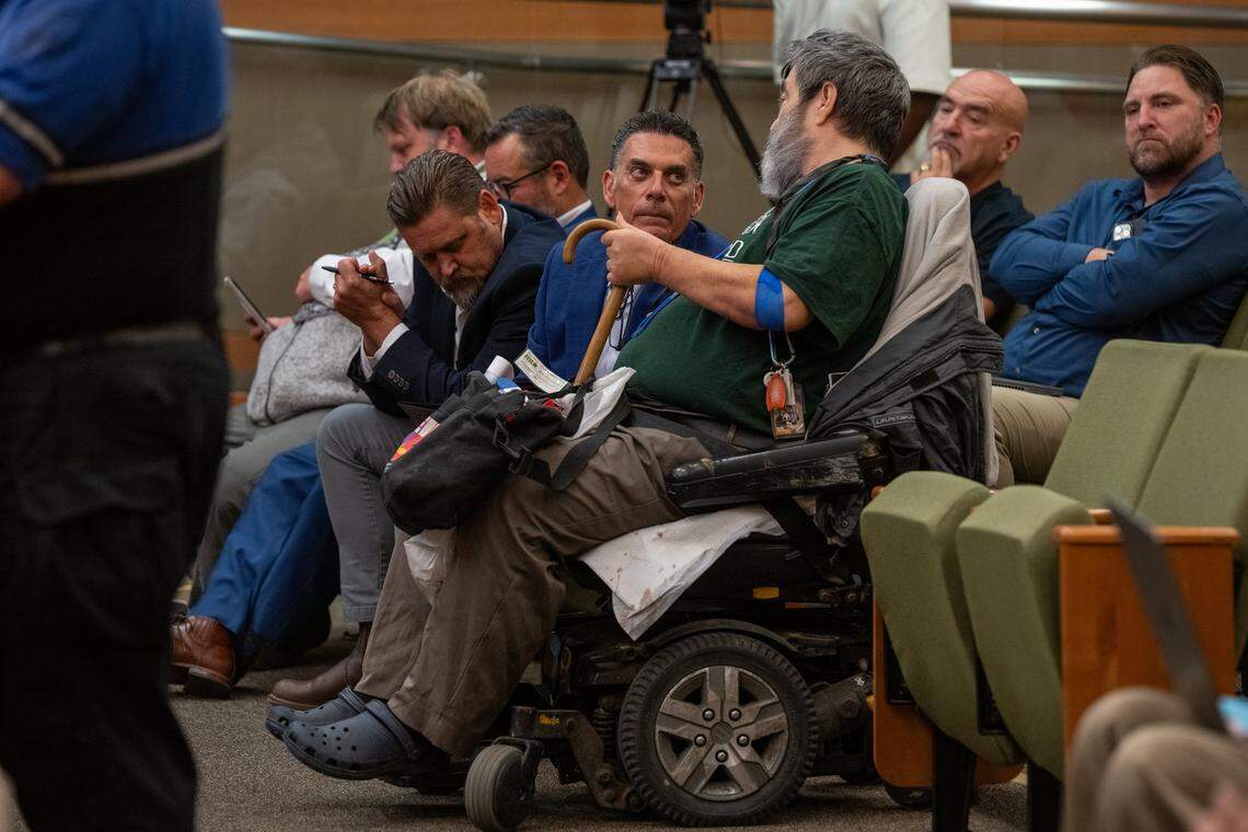 Brian Pedro, director of the Sacramento's Department of Community Response, listens to Jeffrey Tardaguila, who uses a wheelchair, during a City Council meeting on Sept. 16. Tardaguila said he supported the micro-communities for the homeless but was concerned about the proposal to charge residents more than 10% of their gross monthly income. The city approved a 30% fee.