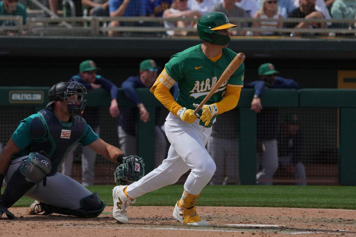 Mar 17, 2025; Mesa, Arizona, USA; Oakland Athletics outfielder JJ Bleday (33) hits a single against the Seattle Mariners in the third inning at Hohokam Stadium. Mandatory Credit: Rick Scuteri-Imagn Images