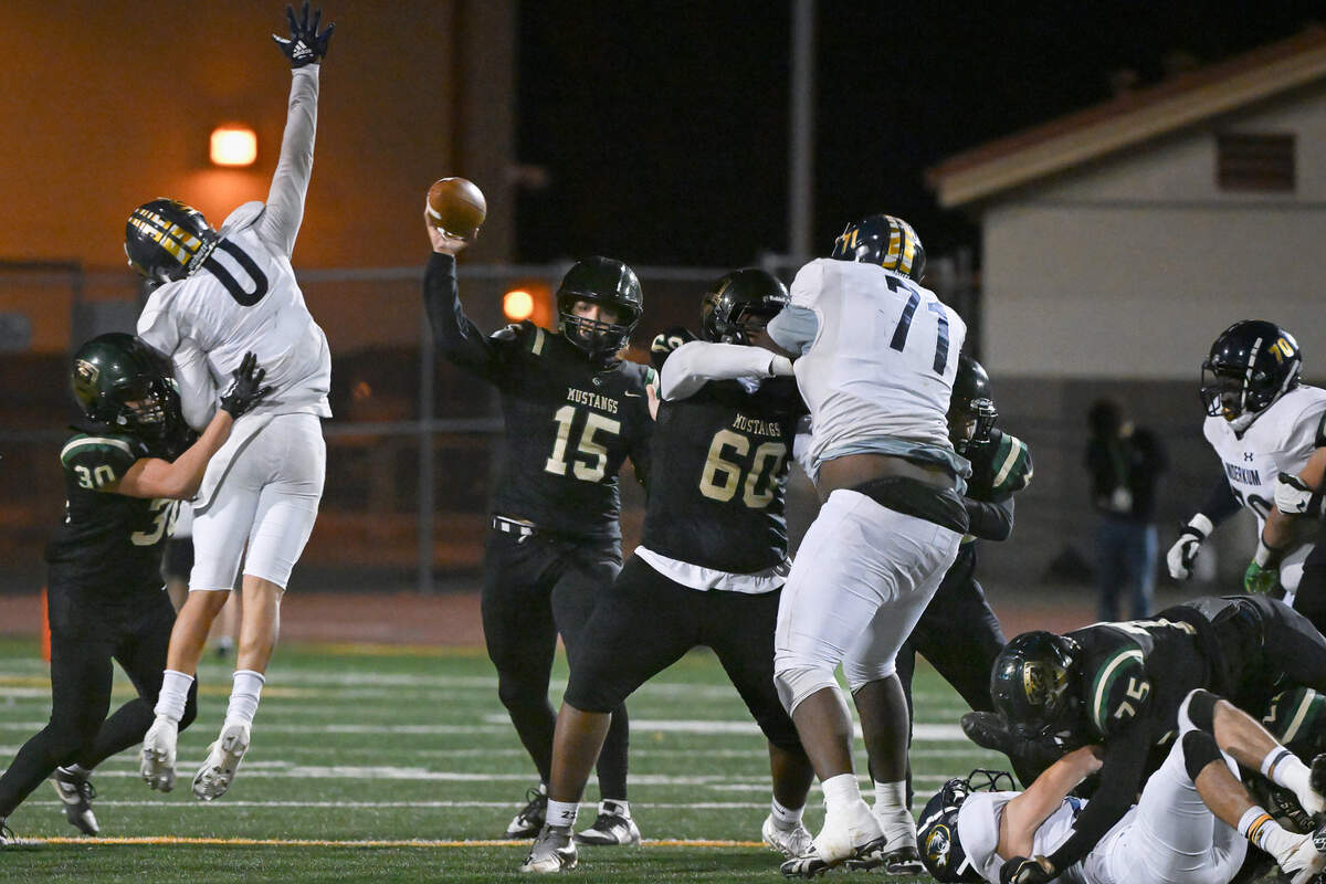 Monterey Trail Mustangs Christian Coronado (15) passes downfield under pressure from Inderkum Tigers free safety Christian Harris (0) in a CIF Sac-Joaquin Section Division I football quarterfinal game on Nov. 10, 2023, at Monterey Trail High School in Elk Grove.