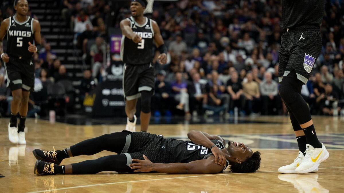 Sacramento Kings guard Davion Mitchell (15) lies on the court after fouled in the first half during a game at Golden 1 Center in Sacramento on Wednesday.