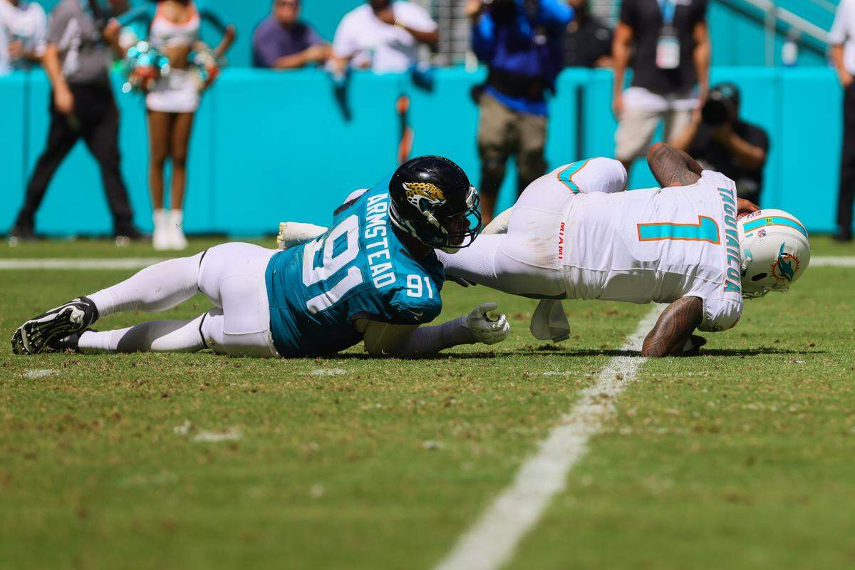 Miami Dolphins quarterback Tua Tagovailoa (1) is sacked by Jacksonville Jaguars defensive end Arik Armstead (91) during the third quarter at Hard Rock Stadium on Sunday. 