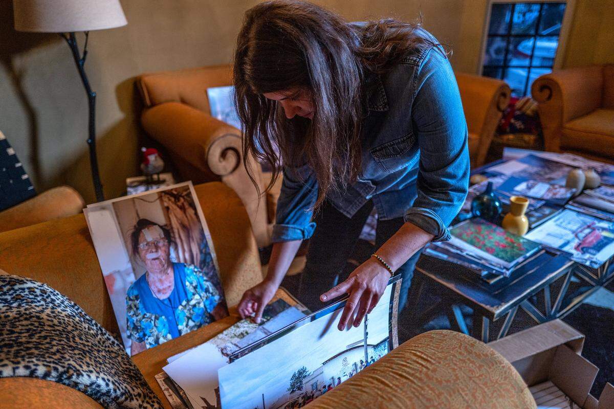 Alina Tyulyu sifts through more than 1,000 photos, including one of a Ukrainian woman with a bandaged face, in her home in Sacramento on Tuesday.