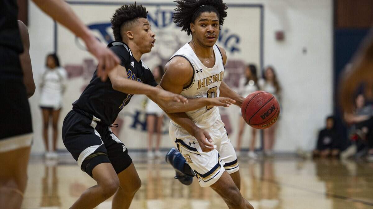 Elk Grove’s Ameere Britton runs around Grant High School’s Jayson Mathews during the high school boys basketball Sac-Joaquin Section Division II playoff game Feb. 21, 2020, at Elk Grove High School.