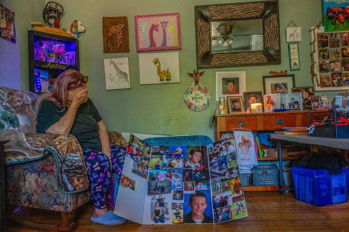 Cheryl Pringle is overcome with emotion as she sits beneath her son’s ashes, which rest on a bookcase above her at left, surrounded by photos from his memorial and candles burning in his memory, two years after his death, on May 19 in Rosemont. She says she wakes up almost every night in tears, knowing she will never see him again. “He loved candles, he loved incense — everything that I loved, he loved,” she said.
