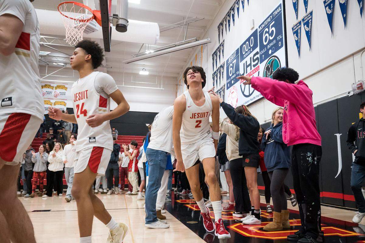 Jesuit Marauder Andrej Stojakovic, center, emerges from a student tunnel in celebration of their 67-65 win over Monterey Trail at the high school boys basketball CIF Sac-Joaquin Section playoff game Wednesday, Feb. 15, 2023, at Jesuit High School in Carmichael. 