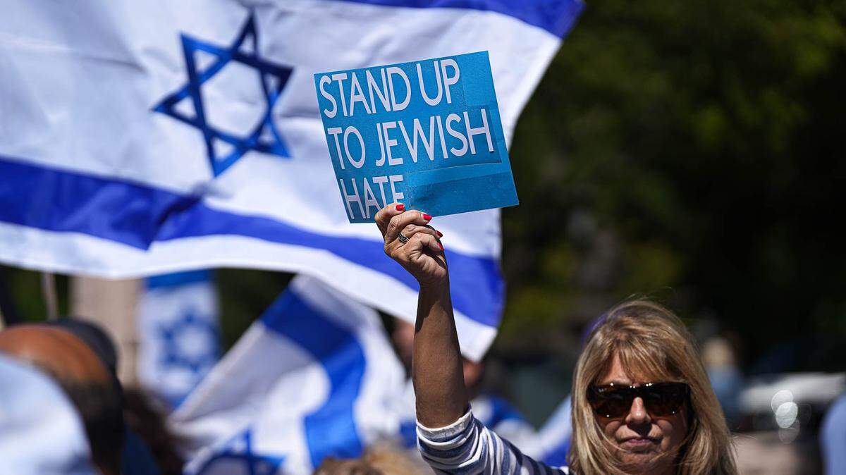 A woman holds up a sign condemning antisemitism at a solidarity rally for Israel outside the Texas Capitol in 2023. "I'm here because I wanted to support the Jewish people and I didn't want to stay silent," she said.
