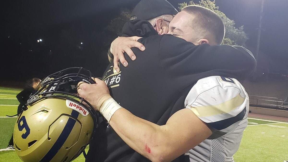 West Park High School senior Westin Wade embraces his grandfather after scoring the winning touchdown in overtime to beat Placer High School in a CIF Sac-Joaquin Section playoff game in Auburn on Friday.
