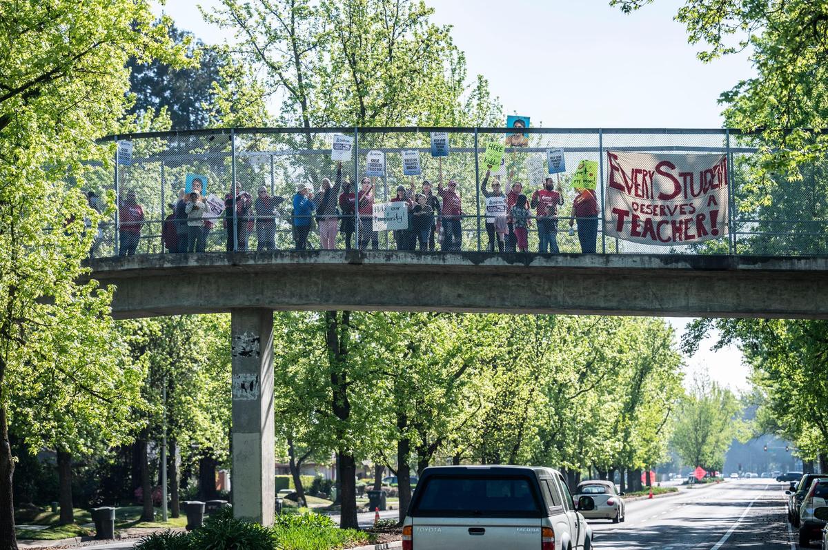 A group from Martin Luther King Jr. K-8 School hold signs in support of the SCTA and SEIU Local 1021 strike as they stand on a pedestrian bridge in Seymour Park on Florin Road on Tuesday.