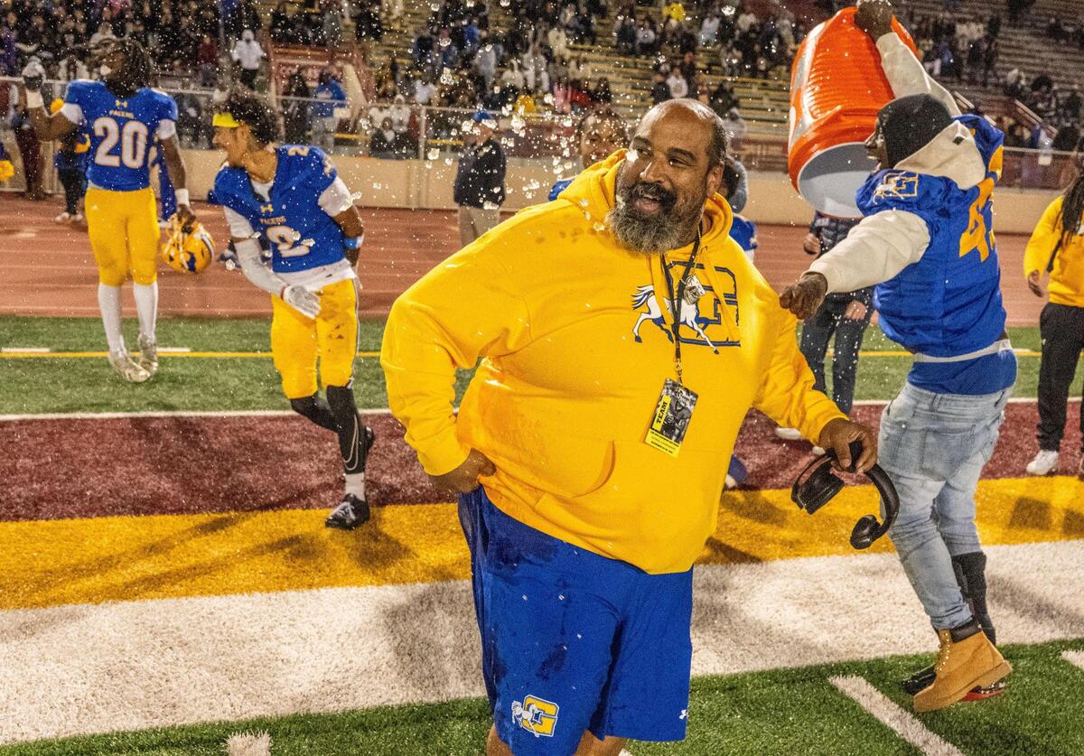 Grant Pacers co-head coach Carl Reed reacts after he was drenched in Gatorade as his team won the CIF Sac-Joaquin Section Division III football championship game against the Woodcreek Timberwolves on Friday at Hughes Stadium.