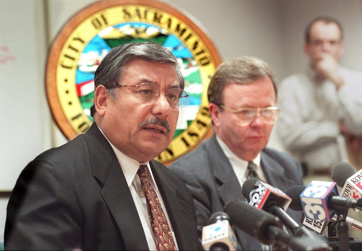 Mayor Joe Serna, Jr., left, and City Manager Bill Edgar preside at a press conference in the City Hall Finance Office conference room in 1997.