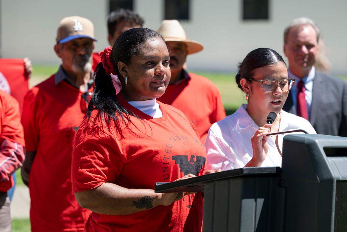 Erika Deluque, left, talks at a press conference outside the Capitol for Senate Bill 1299 on Monday, as she recounts her experience with the help of an interpreter, right, when she became sick while working in triple-digit heat in a Dixon tomato field.