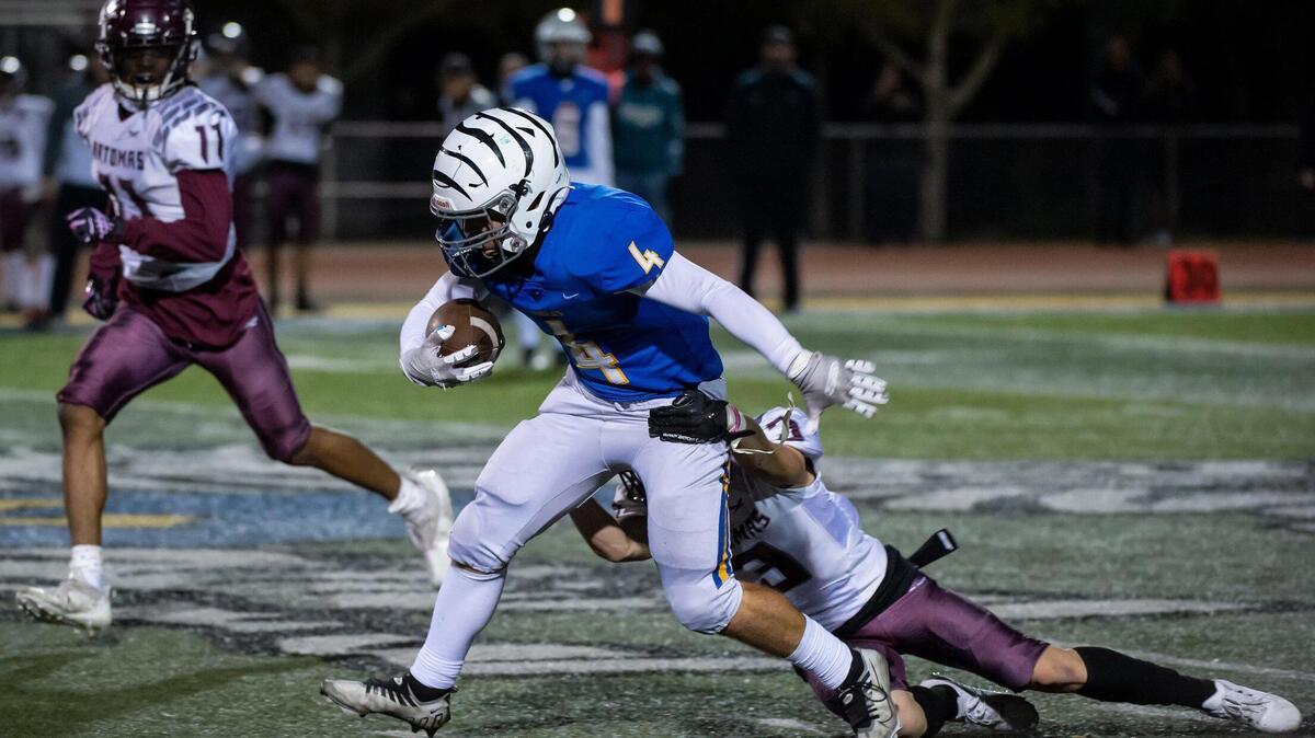 Lincoln Fighting Zebras’ Gianni Faria (4) runs the ball for a first down before being tackled by Natomas Nighthawks Angel Gutierrez (3) during the second quarter in the first round Division IV playoff game Friday, Nov. 4, 2022, at Lincoln High School in Lincoln.