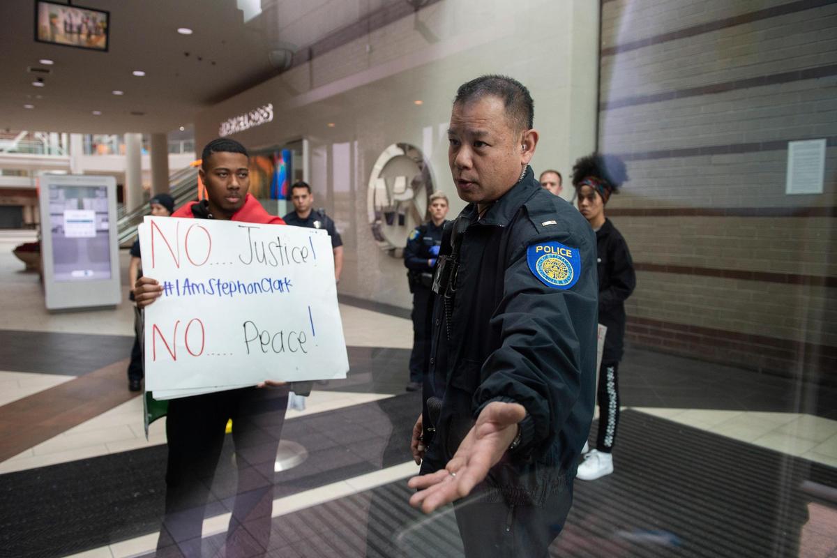 Sacramento Police officers escort protesters from the Arden Fair Mall in Sacramento Calif. after they staged an overnight sit-in Sunday, March 3, 2019, following the Sacramento District Attorney’s decision not to arrest officers involved in last year’s shooting of the unarmed black man.