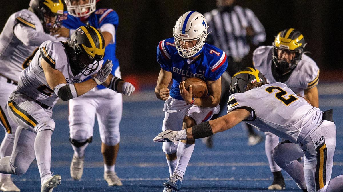 Folsom bulldogs QB Tyler Tremain gains yardage on keeper and is tackled by Del Oro Golden Eagles TJ Willson during a game at Folsom High School on Friday, March 26, 2021, in Folsom.