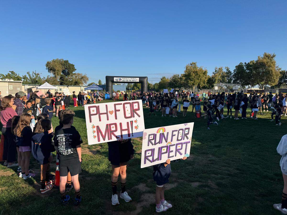 Dozens of Phoebe Hearst sixth-grade students wear flash tattoos and hold signs in support of teachers Jeanine Rupert (who was reassigned to a different school) and Mark Henrikson (who was put on administrative leave) during a Jog-A-Thon fundraiser on Friday, Oct. 10, 2025.