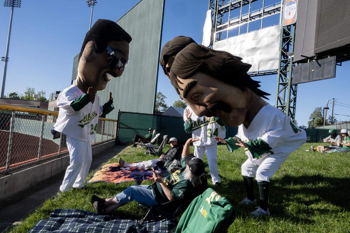 Audrey Williamson of West Sacramento is greeted by Rickey Henderson, Rollie Fingers and Dennis Eckersley before the start of the Athletics and Houston Astros game on Friday at Sutter Health Park in West Sacramento.