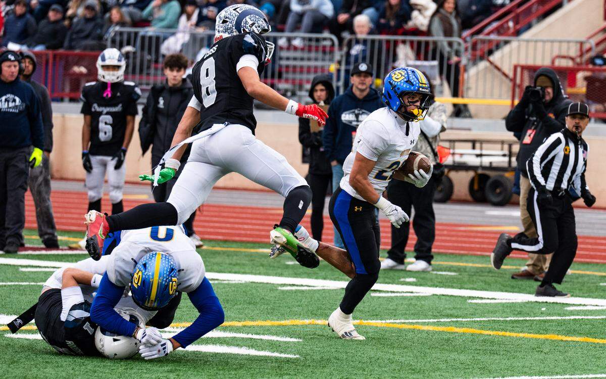 Sutter Huskies running back Max Bringgold (22) eludes Casa Roble Rams strong safety Karter Coss (8) on his way to a second-quarter touchdown in the CIF Sac-Joaquin Section Division V championship at Hughes Stadium in Sacramento on Friday.