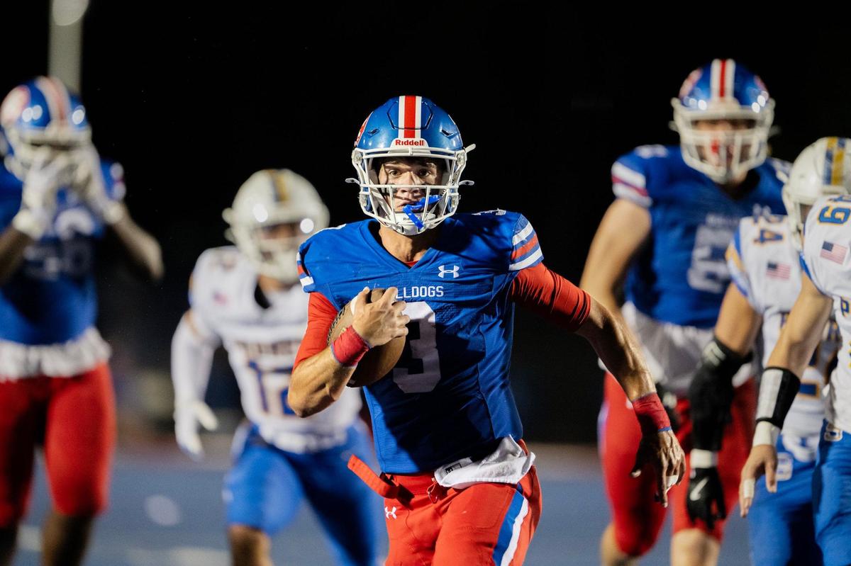 Bulldog quarterback Ryder Lyons, (3) runs through the Serraq Padres defense for a touchdown in the first quarter on Friday at Folsom High School.