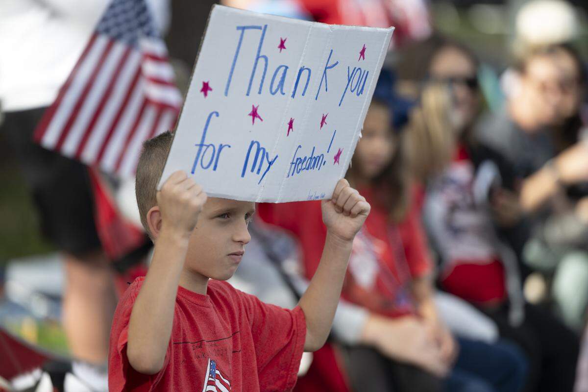 Logan Stuhr holds a sign that reads “thank you for my freedom,” during a Veterans Day parade in Folsom on Tuesday, Nov. 11, 2025.