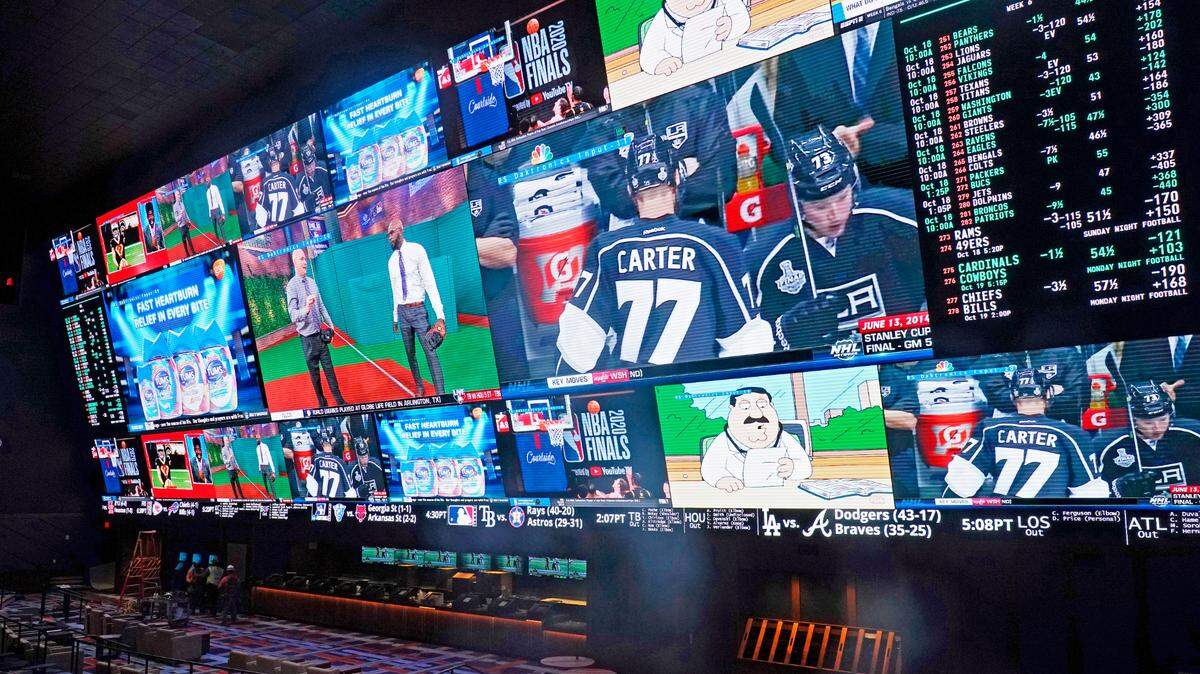 Various California groups are vying for control of sports betting through ballot initiatives. This photo shows TV screens and betting odds in the sports book at the Circa Resort & Casino in 2020 in Las Vegas.