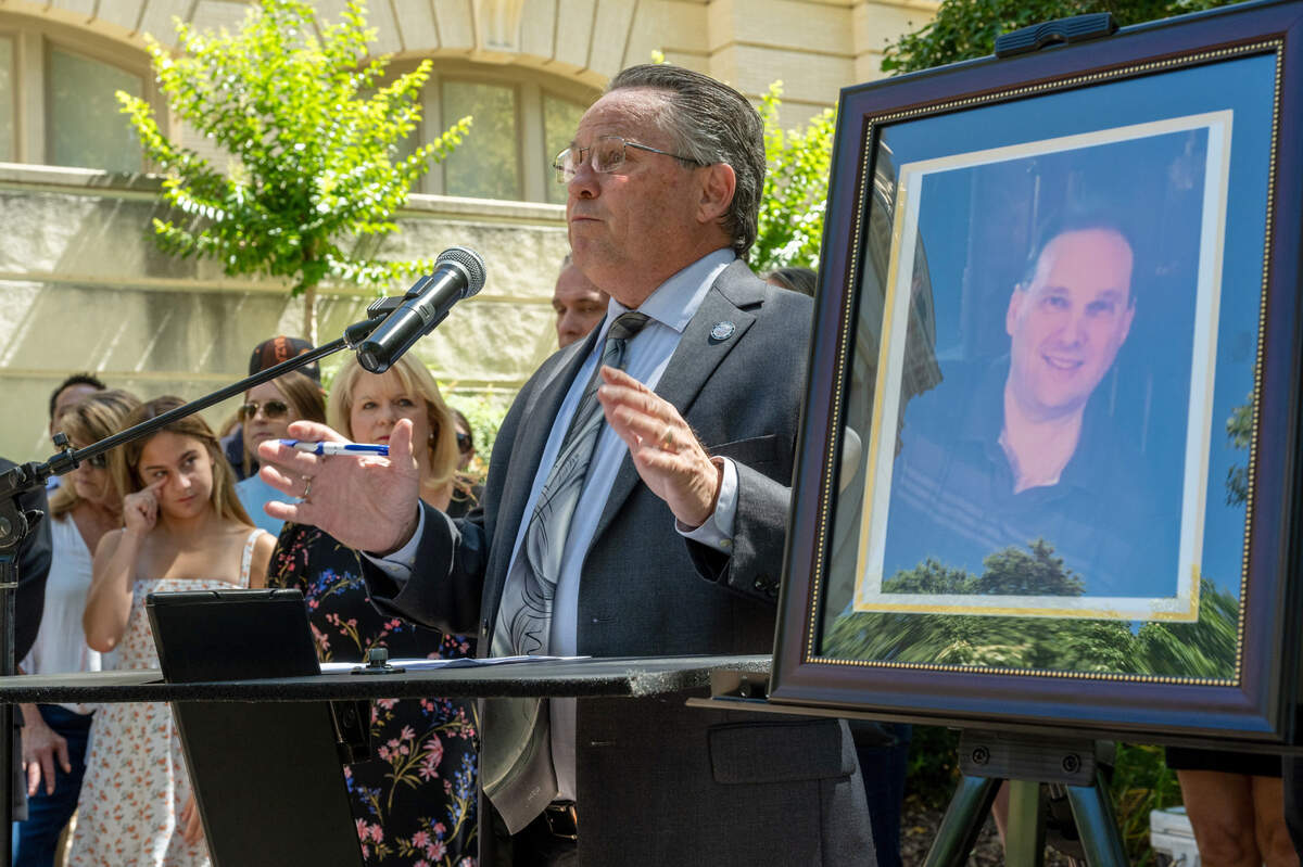 Topo Padilla, co-owner of Greg Padilla Bail Bonds and employer of slain bail bondsman Kevin Brace, speaks next to a photogragh of Brace at a press conference on Thursday, June 6, 2024, to demand the Sacramento City Council protect public safety funding. Brace’s niece Jordan Brace, at left, also spoke.