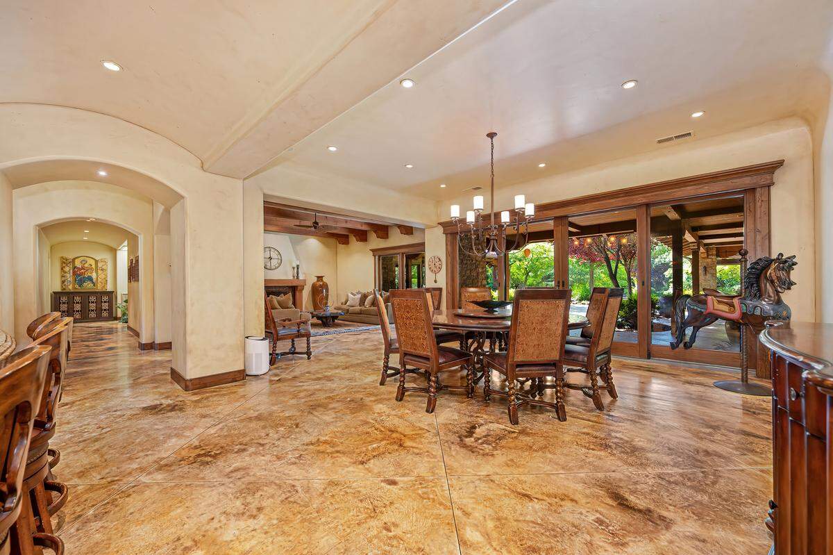 Built by locally renowned Higgins Construction, the roughly 6,300-square-foot main house opens from its chef’s kitchen and main living spaces to a sweeping patio “oasis” with views of the yard.