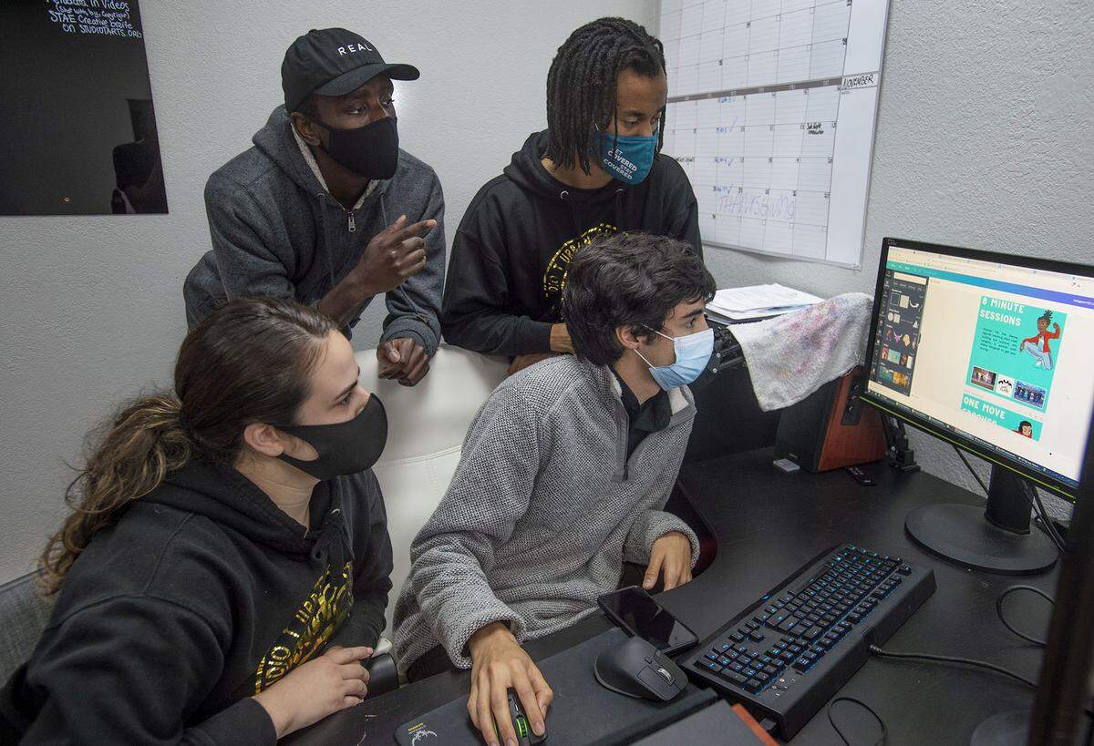 Teaching staff and program leaders, Hannah Feuerwerker and Maxwell Adams, front, and Sean Maloba and Lance Casey II, back, work together on a computer at Studio T Arts and Entertainment on Wednesday, Nov. 17, 2021, in Sacramento. Studio T Arts is a grassroots nonprofit that recently opened a youth driven media lab. They’re asking Book of Dreams $7,500 in donations to purchase eequipment for their lab.