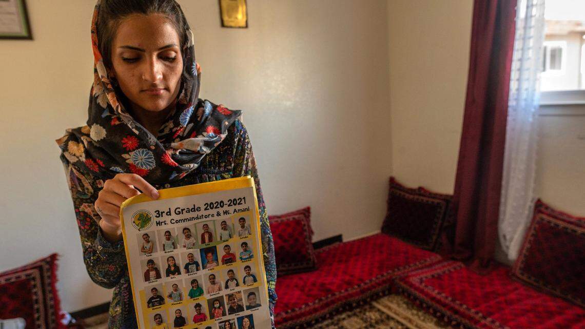 Behshta, 21, holds a school picture showing her youngest sister Neda, 9, second from left in top row, on Wednesday, Aug. 25, 2021, as she worries in their Arden Arcade bedroom whether his sisters will return from Afghanistan. She said the schools call every day asking when Neda, of Dyer-Kelly Elementary School and Sabrina, 15, of Encina High School, will return to class. The family explained that they are in hiding from the Taliban and cant get to the airport.