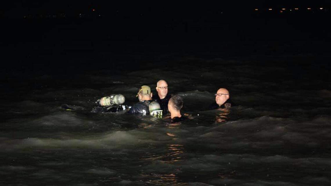 Police and firefighters try to rescue a woman from a car after it sank into San Francisco Bay near a San Leandro marina, police say. The woman died.