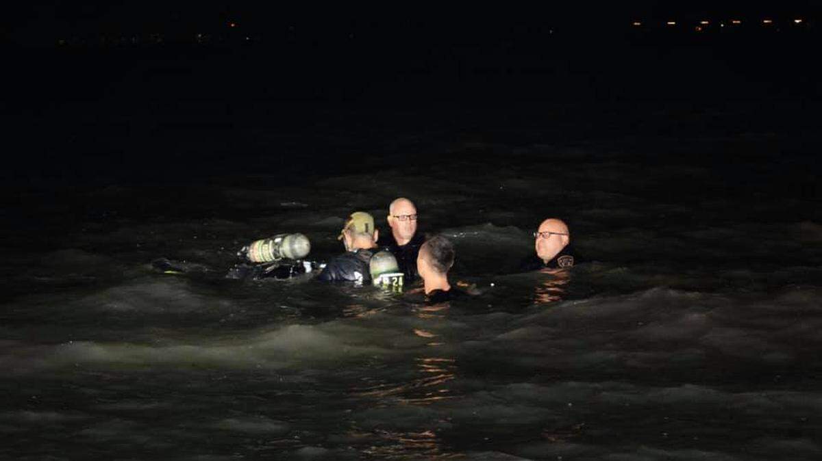Police and firefighters try to rescue a woman from a car after it sank into San Francisco Bay near a San Leandro marina, police say. The woman died.