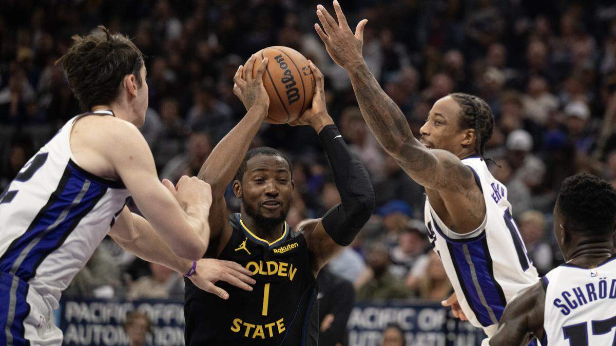 Golden State Warriors forward Jonathan Kuminga cuts through Sacramento Kings guard DeMar DeRozan and center Maxime Raynaud in the first half on Wednesday.