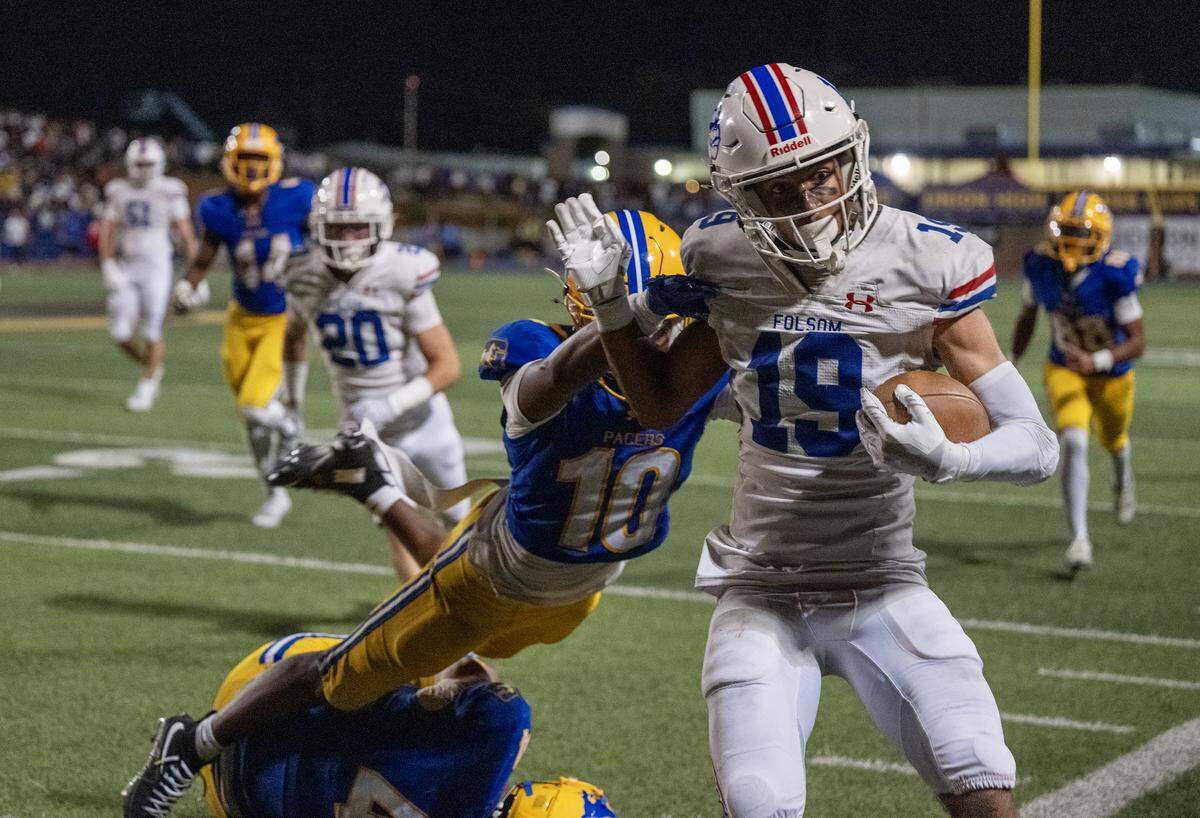 The Folsom Bulldogs' Jason Hill Jr. (19) is pushed out of bounds by the Grant Pacers' Jaylen Rabon (10) in the first half on Saturday in Del Paso Heights.