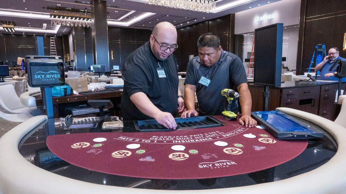 Table games workers Tim Lee, left, and Fred Lacsina work to set up a black jack table on Monday, Aug. 15, 2022, at the Sky River Casino in Elk Grove. 