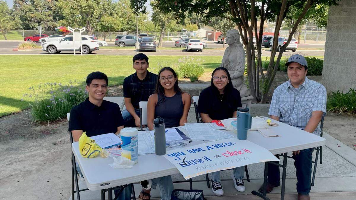 Jimena Romero, middle, tables with other California Youth Voters volunteers outside of St. Mary’s Catholic Church.