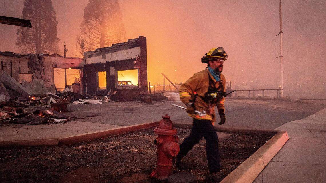A firefighter battles the Dixie Fire as it tears through the Greenville community in Plumas County, Calif., Wednesday, Aug. 4, 2021. The fire leveled multiple historic buildings and dozens of homes in central Greenville. (AP Photo/Noah Berger)