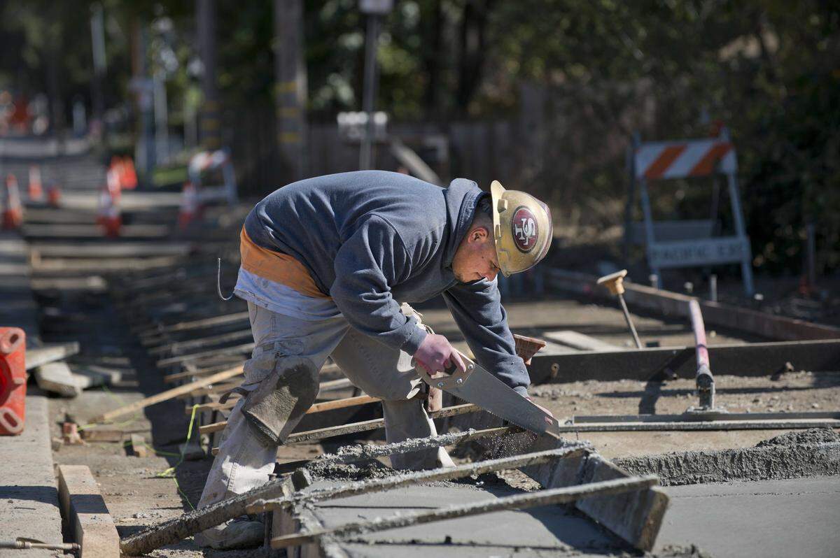 A construction worker cuts lumber while building a sidewalk along Marconi Avenue in Carmichael in 2013. Sidewalk construction projects like this are often built in phases as local agencies compete for limited state Active Transportation Program grants to fund pedestrian safety improvements.