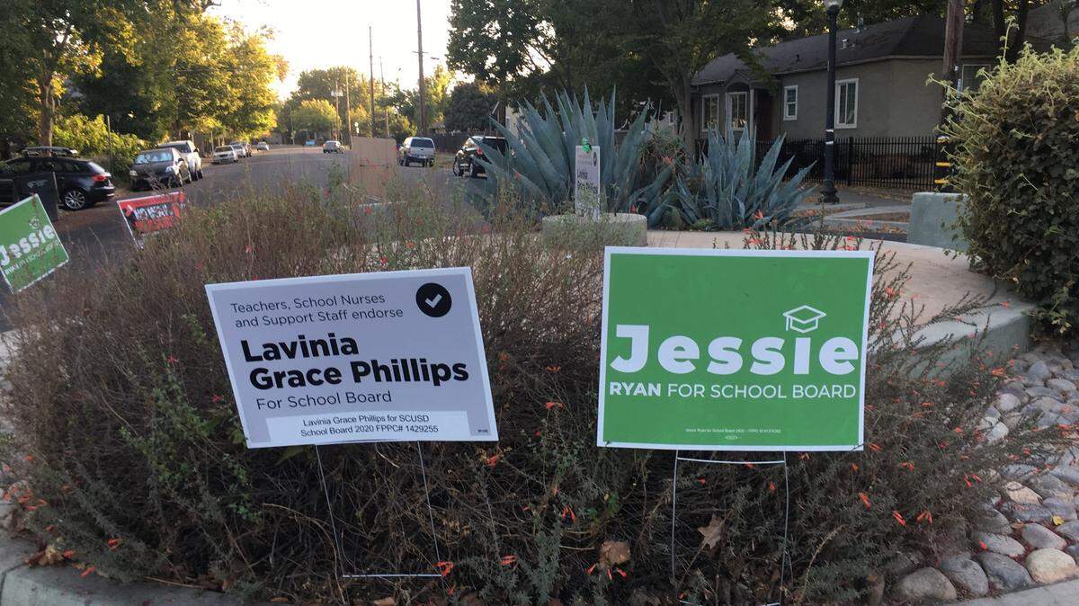 Yard signs are shown in a roundabout in Sacramento’s Oak Park neighborhood on Thursday, Oct. 15, 2020. Sacramento City Unified School District Board President Jessie Ryan is running for reelection, challenged by Oak Park Neighborhood Association President Lavinia Grace Phillips.