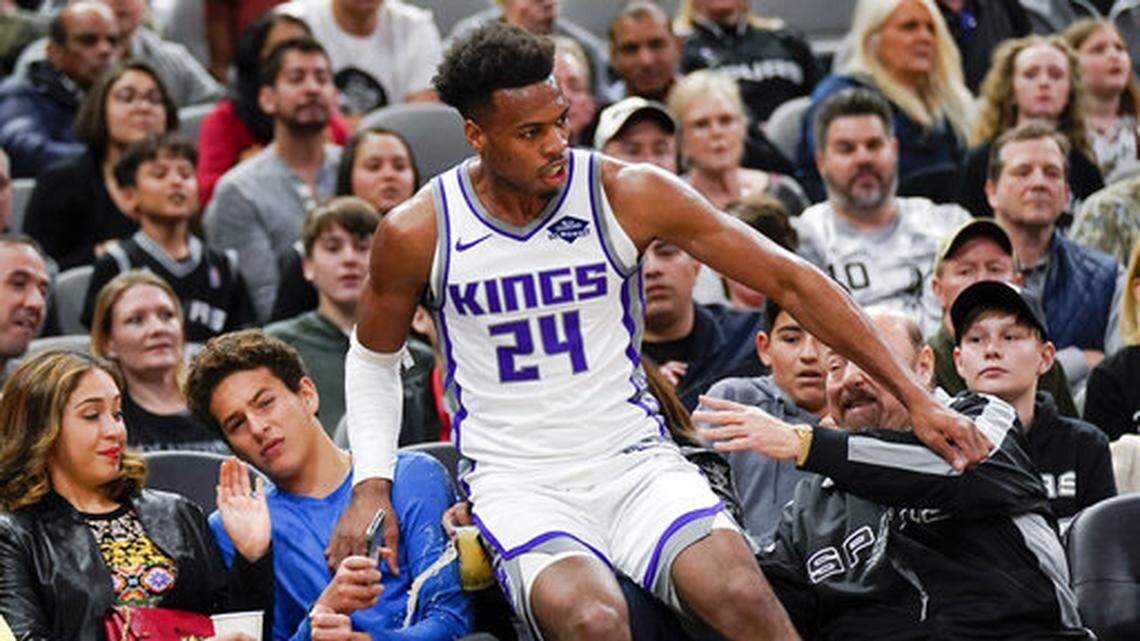 Sacramento Kings’ Buddy Hield falls onto fans after running out of bounds during the first half of an NBA basketball game against the San Antonio Spurs, Sunday, March 31, 2019, in San Antonio. Sacramento won 113-106. (AP Photo/Darren Abate)